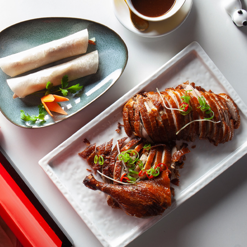 PATO LAQUEADO CON CREPS, GUARNICIÓN DE PEPINO, PUERRRO, Y SALSA HOISIN