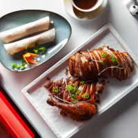 PATO LAQUEADO CON CREPS, GUARNICIÓN DE PEPINO, PUERRRO, Y SALSA HOISIN